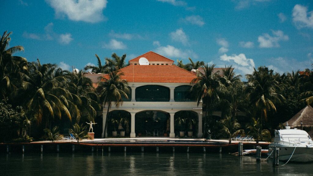 The Art of Drawing Readers In: Your attractive post title goes here Stunning waterfront resort featuring a yacht and palm trees under a bright summer sky.